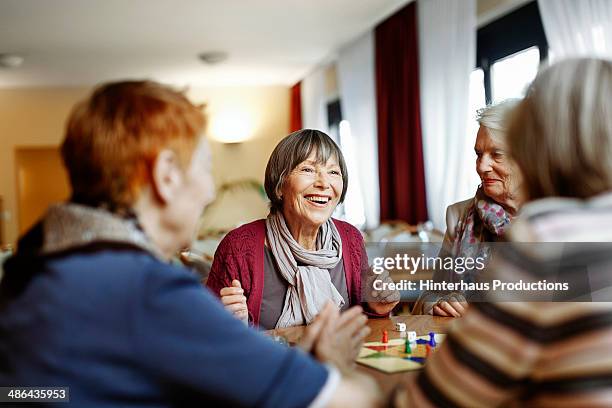 senior women playing board game - elderly people stock-fotos und bilder