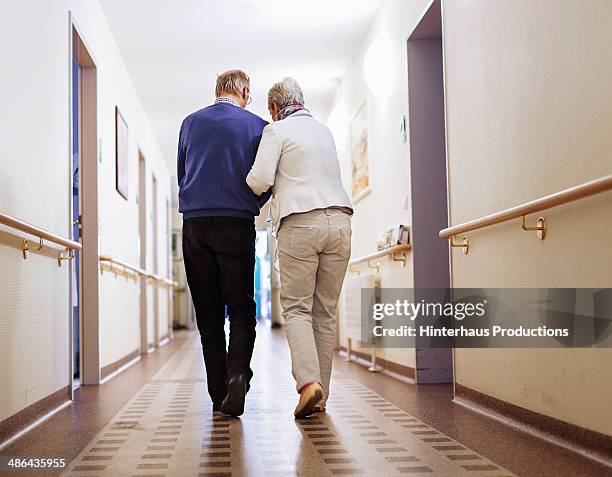 senior couple senior home - senior couple holding hands stock pictures, royalty-free photos & images