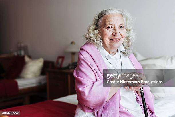 senior woman in retirement home - rentnersiedlung stock-fotos und bilder