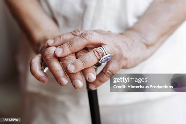 senior hands with crutch - spazierstock stock-fotos und bilder