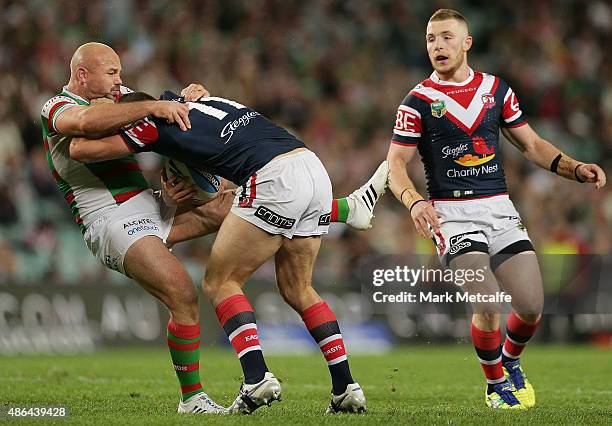 Boyd Cordner of the Roosters is tackled by Glenn Stewart of the Rabbitohs during the round 26 NRL match between the Sydney Roosters and the South...