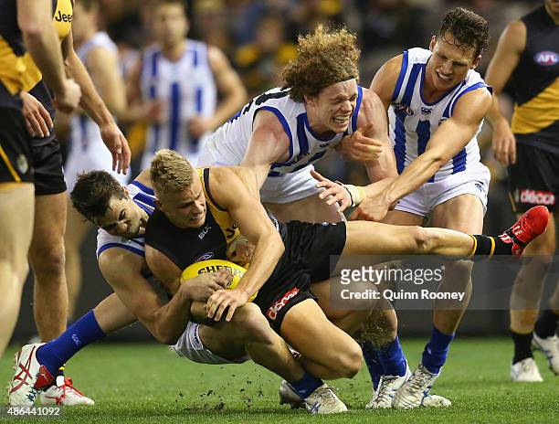 Brandon Ellis of the Tigers is tackled by Taylor Garner of the Kangaroos during the round 23 AFL match between the Richmond Tigers and the North...
