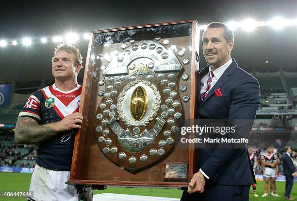 Jake Friend and Mitchell Pearce of the Roosters pose with the J.J. Giltinan Shield for winning the minor premiership during the round 26 NRL match...