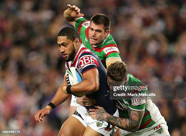 Isaac Liu of the Roosters is tackled by Chris McQueen and Tim Grant of the Rabbitohs during the round 26 NRL match between the Sydney Roosters and...