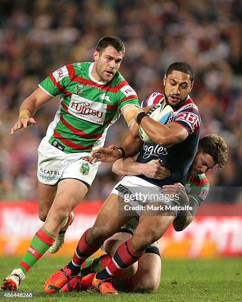 Isaac Liu of the Roosters is tackled by Chris McQueen and Tim Grant of the Rabbitohs during the round 26 NRL match between the Sydney Roosters and...