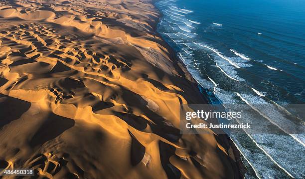 aerial view of sand dunes and ocean - aerial desert stock pictures, royalty-free photos & images