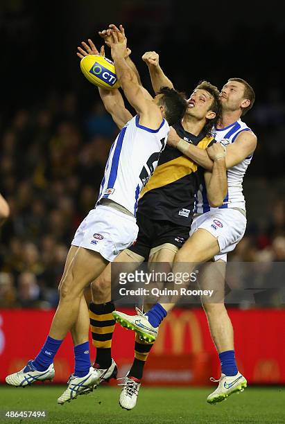 Ivan Maric of the Tigers competes for a mark against Robbie Tarrant and Lachlan Hansen of the Kangaroos during the round 23 AFL match between the...