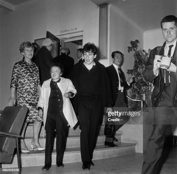 French singer Edith Piaf, accompanied by her husband Theo Sarapo, leaves the Ambroise Paré clinic on May 27, 1963 in Neuilly after a eight-week cure.
