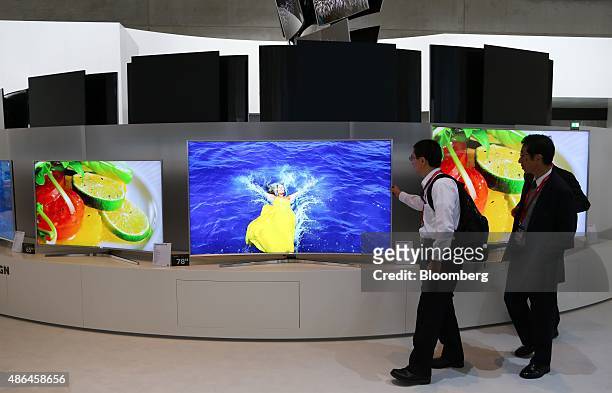 Visitors look at the Samsung Ultra High Definition televisions at the Samsung Electronics Co. Exhibition stand during the IFA International Consumer...