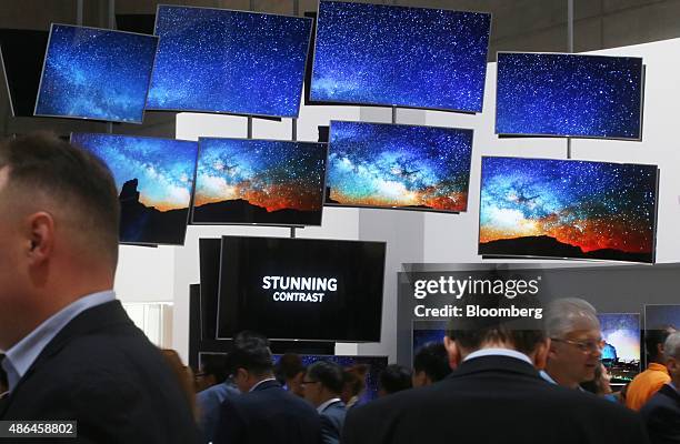 Visitors look at the Samsung Ultra High Definition televisions at the Samsung Electronics Co. Exhibition stand during the IFA International Consumer...