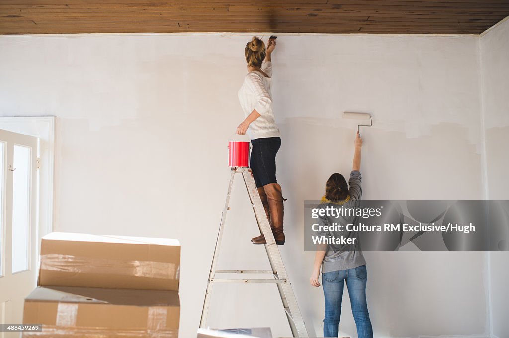 Two young woman decorating new home