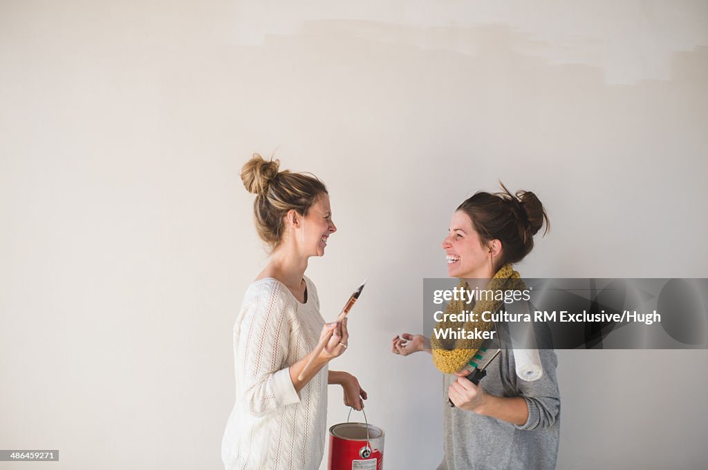 Two young women with paintbrushes chatting