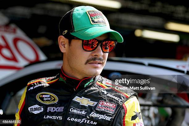 Kyle Larson, driver of the Mello Yello Chevrolet, stands in the garage area during practice for the NASCAR Sprint Cup Series Bojangles' Southern 500...