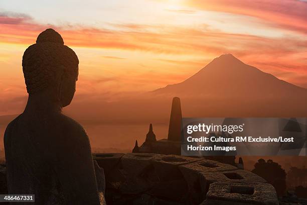 buddha at sunset, the buddhist temple of borobudur, java, indonesia - glow rm fotografías e imágenes de stock