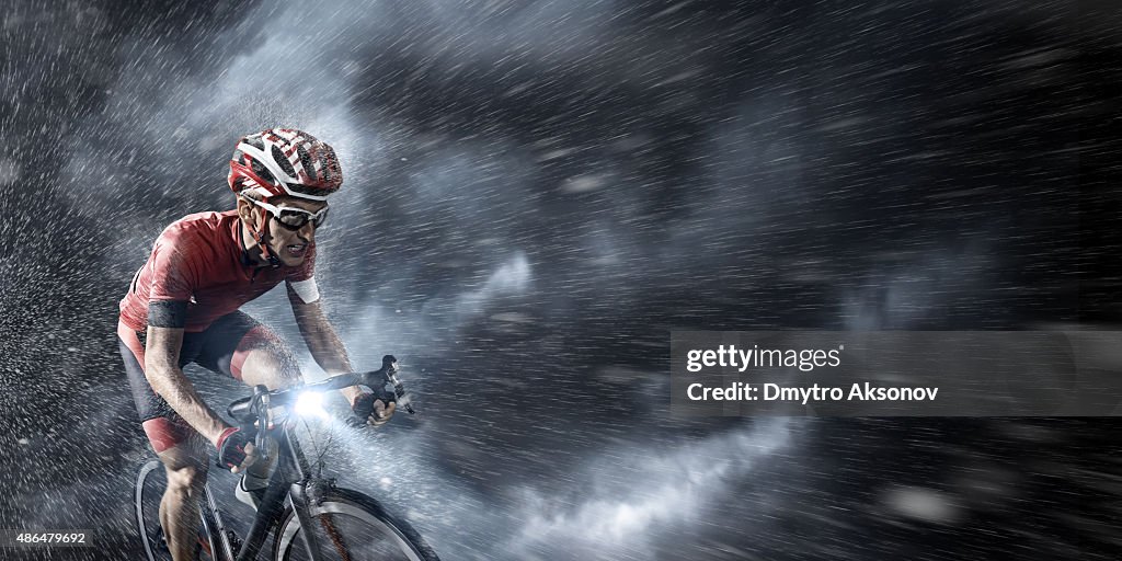 Professional cyclist under stormy sky