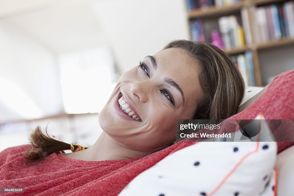 Portrait of smiling woman relaxing on a couch in her apartment
