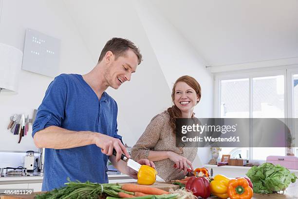 young couple preparing food in kitchen - küchenmesser stock-fotos und bilder