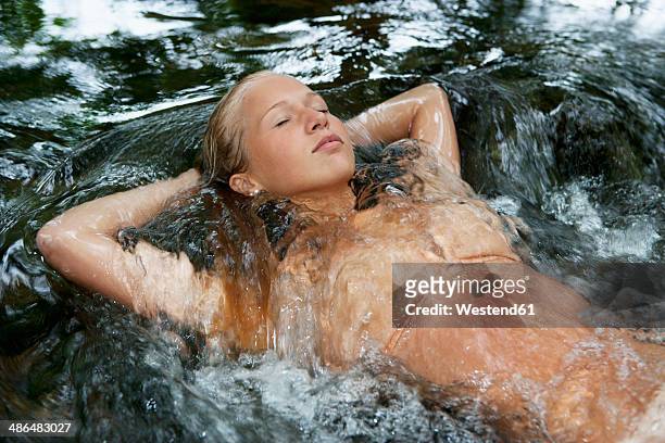 austria, salzkammergut, mondsee, teenage girl floating in a brook - girls in bras fotos stock-fotos und bilder