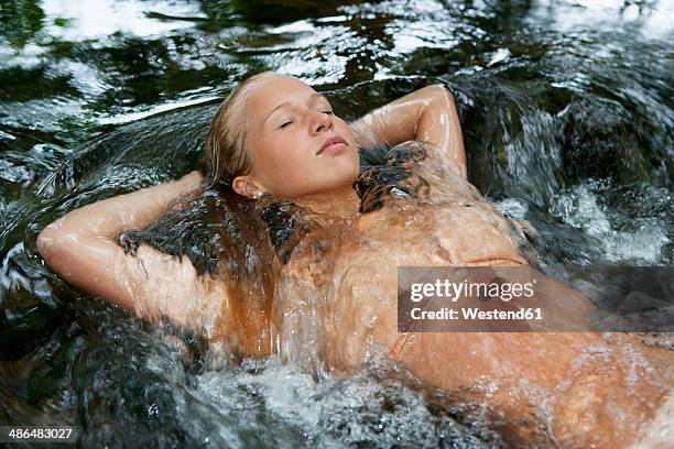 austria, salzkammergut, mondsee, teenage girl floating in a brook - couleur chair photos et images de collection