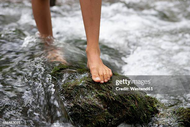 austria, salzkammergut, mondsee, feet of teenage girl crossing a brook - barfota bildbanksfoton och bilder