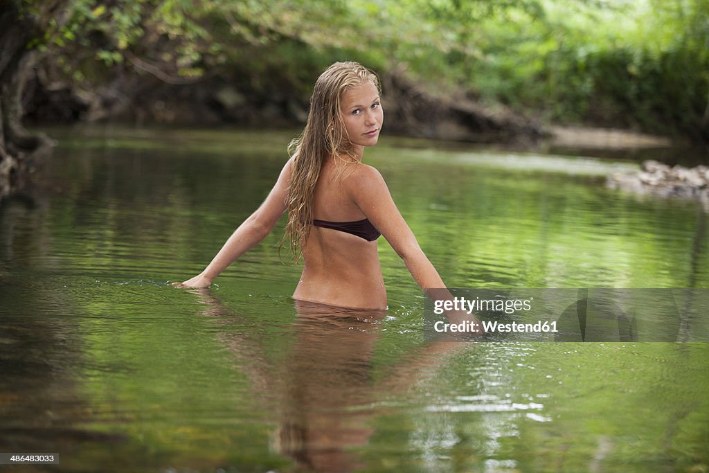 Austria, Salzkammergut, Mondsee, teenage bathing in a brook