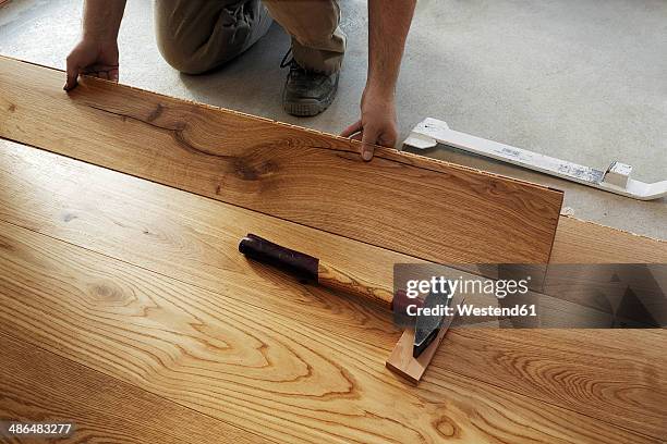 man laying finished parquet flooring, close-up - parqué fotografías e imágenes de stock