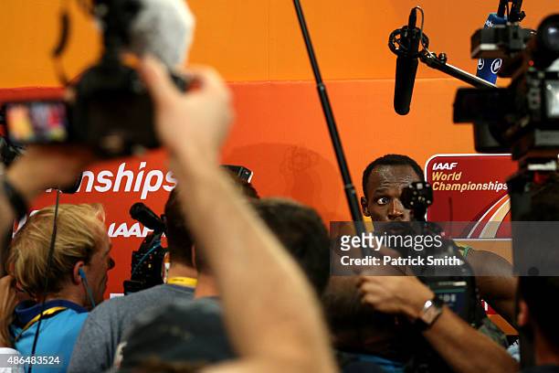 Usain Bolt of Jamaica speaks to the media after crossing the finish line to win gold in the Men's 200 metres final during day six of the 15th IAAF...