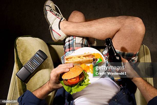 a man eats junk food - schlechte angewohnheit stock-fotos und bilder