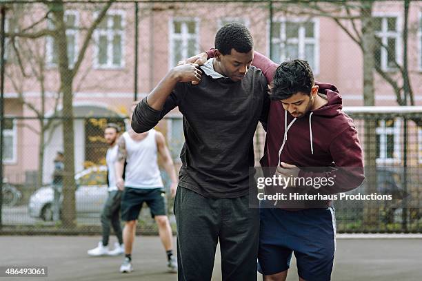 helping injured team mate - men carrying injured person stock pictures, royalty-free photos & images