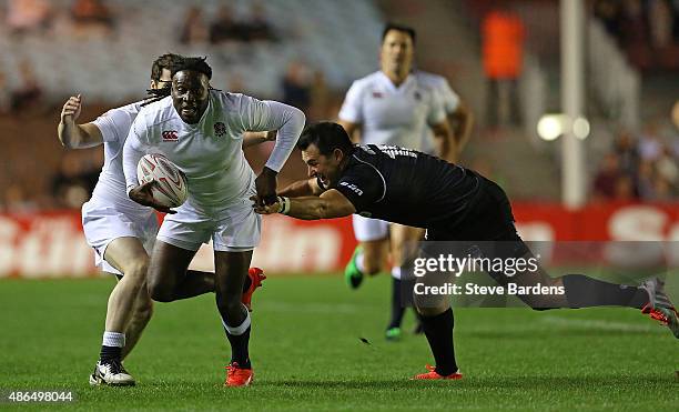 Paul Sackey of England breaks away from Thinus Delport of the Rest of the World during the Rugby Aid 2015 celebrity rugby match between England and...