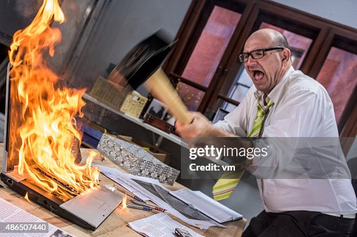 Ältere Erwachsene Geschäftsmann großer laptop auf Feuer mit hammer Ältere Erwachsene Geschäftsmann großer laptop auf Feuer mit hammer