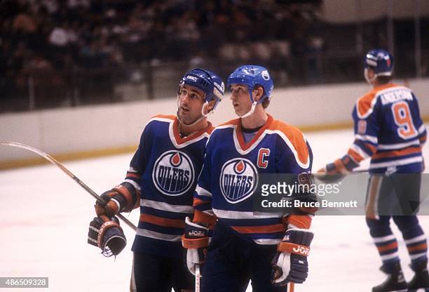 Wayne Gretzky and Paul Coffey of the Edmonton Oilers talk on the ice during an NHL game against the New York Rangers on March 28, 1986 at the Madison...