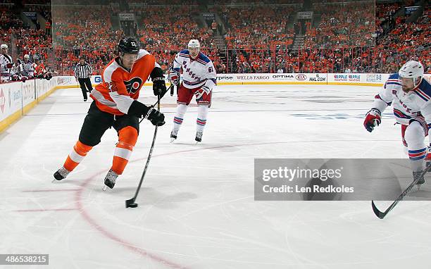Luke Schenn of the Philadelphia Flyers skates the puck against Rick Nash and Kevin Klein of the New York Rangers in Game Three of the First Round of...