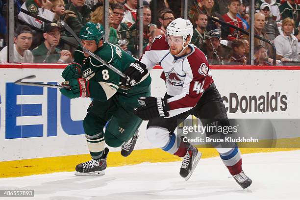 Brad Malone of the Colorado Avalanche and Cody McCormick of the Minnesota Wild skate to the puck during Game Four of the First Round of the 2014...
