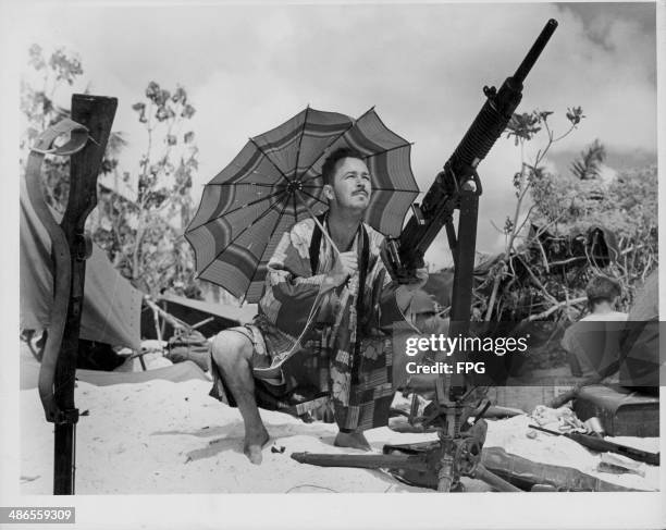 Coast Guard manning his machine gun whilst wearing a Japanese silk kimono, during the Pacific Campaign of World War Two, Saipan, circa 1941-1945.