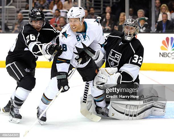 Joe Pavelski of the San Jose Sharks provides a screen in front of Jonathan Quick of the Los Angeles Kings as Slava Voynov attempts to move him during...