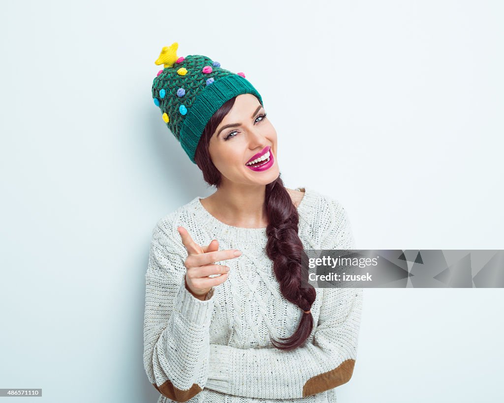 Glückliche Frau im winter outfit zeigen in die Kamera.