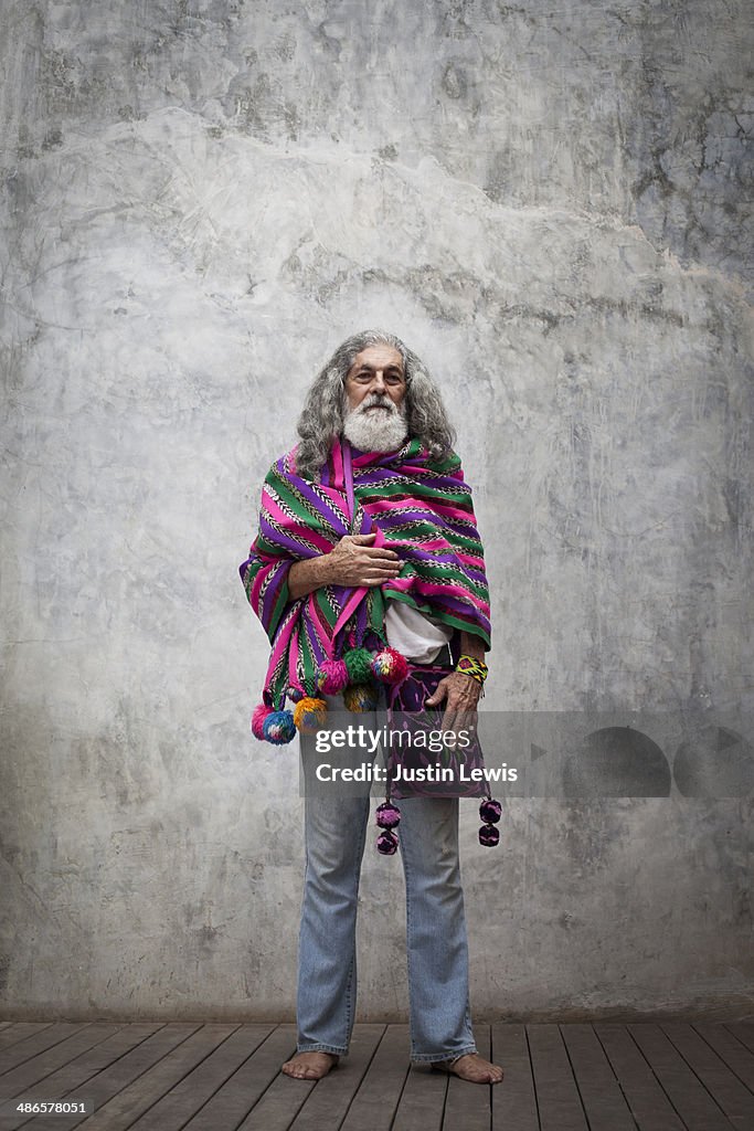 Colorfully dressed older man standing solo