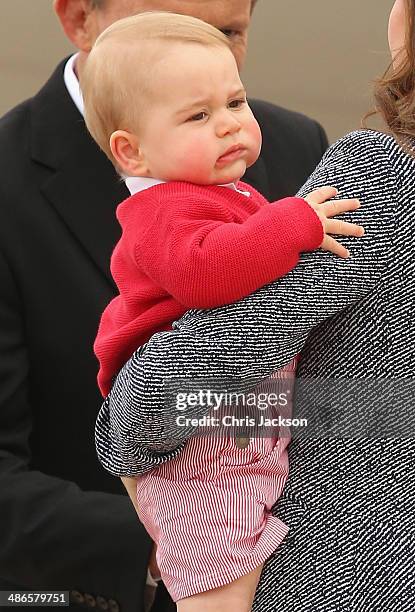 Australian Prime Minister Tony Abbott looks on as Catherine, Duchess of Cambridge holds Prince George of Cambridge as they leave Fairbairne Airbase...