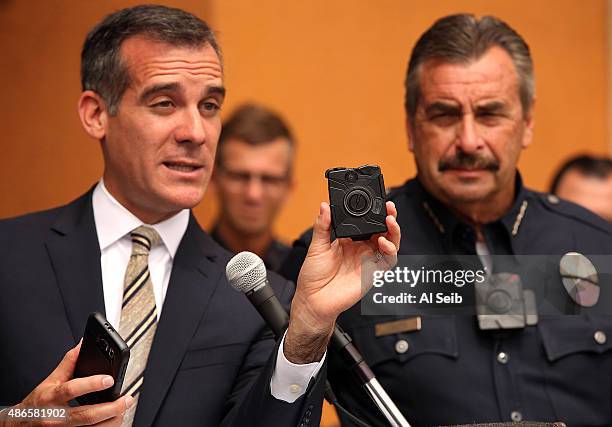 Los Angeles Mayor Eric Garcetti, left, with LAPD Chief Charlie Beck, right, who is wearing a body camera, shows the new LAPD body camera and cell...