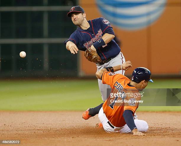 Brian Dozier of the Minnesota Twins throws over Carlos Correa of the Houston Astros to complete a double play in the first inning at Minute Maid Park...