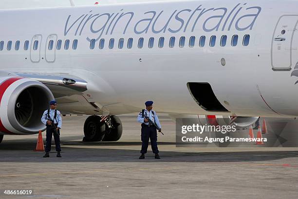 Members of the Indonesian military stands guard near a Virgin Australia airplane, which was forced to land at International Ngurah Rai Airport after...