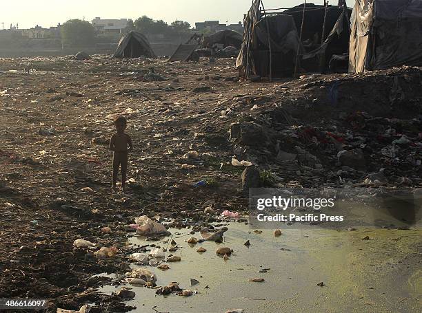 Pakistani gypsy children playing in the dry river ravi near their slum home on the eve of world malaria day, in Lahore on April 24, 2014. World...