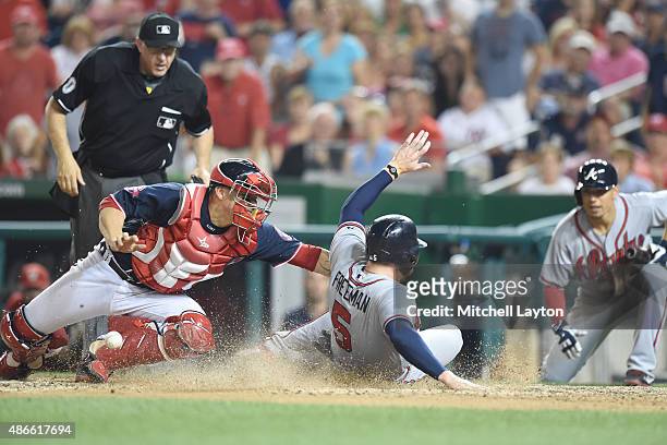 Freddie Freeman of the Atlanta Braves beats tag from Jose Lobaton of the Washington Nationals to tie the game in the eight inning on a Nick Swisher...