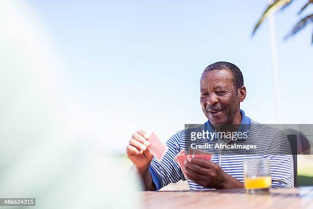 afrikanische senior spielt eine karten - thinking of you card stock-fotos und bilder