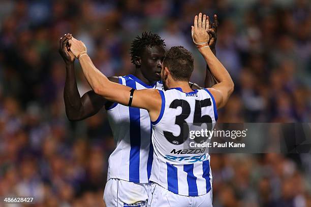 Majak Daw and Aaron Black of the Kangaroos celebrate a goal during the round six AFL match between the Fremantle Dockers and the North Melbourne...