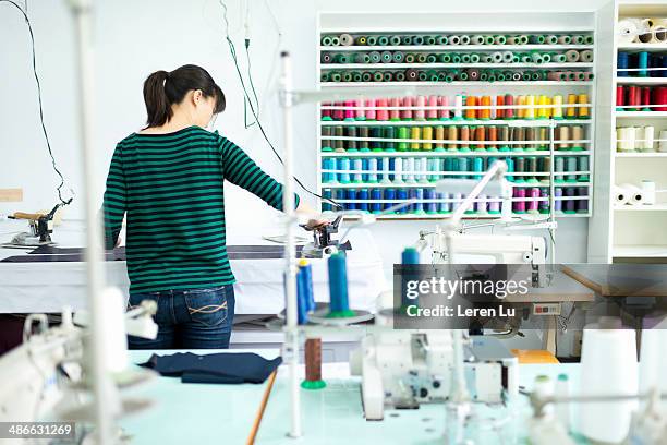 dressmaker ironing a material on worktable. - macchina per cucire foto e immagini stock