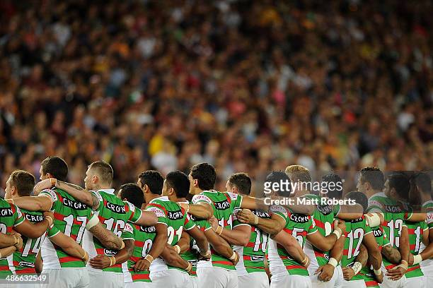 Rabbitohs players stand in silence as an Australian Soldier plays the Last Post to mark Anzac Day before the round 8 NRL match between the Brisbane...