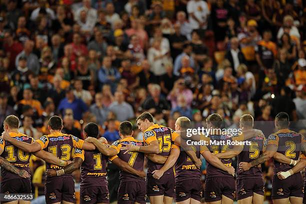 Broncos players stand in silence as an Australian Soldier plays the Last Post to mark Anzac Day before the round 8 NRL match between the Brisbane...