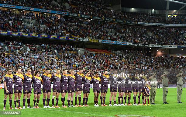 Broncos players embrace for the national anthem and the last post for ANZAC day before the round 8 NRL match between the Brisbane Broncos and the...